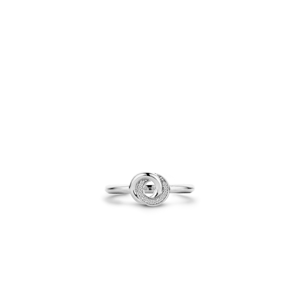 Imagemde vista superior de de um anel de prata de lei 925 banhado a ródio, apresentando um design circular com zircónias. O anel tem uma aparência elegante e moderna, com as zircánias adicionando um toque de brilho ao motivo central em espiral que fica no topo da banda. A imagem destaca o acabamento prateado reflexivo do anel e a configuração precisa das pequenas zircônias de corte redondo que realçam sua elegância