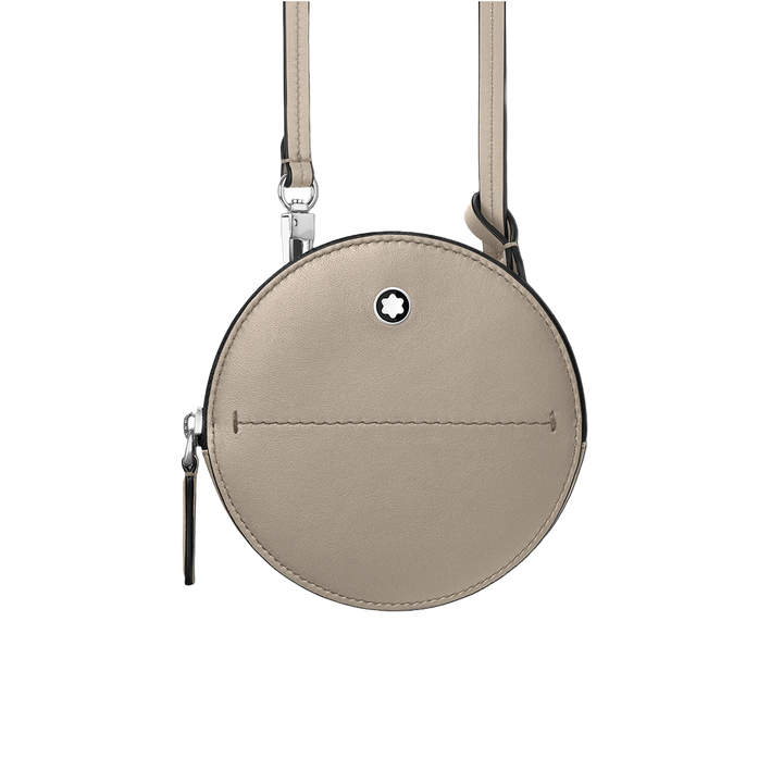 Uma bolsa redonda bege com zíper prateado e um pequeno logotipo circular preto no centro. A bolsa tem uma costura visível ao longo do meio e está presa a uma alça ajustável da mesma cor. O fundo é branco, destacando o design e a cor da bolsa