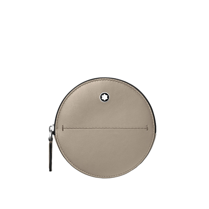 Uma bolsa redonda de couro bege com zíper prateado e um pequeno logotipo circular no centro. A bolsa tem uma linha de costura visível que a divide em duas metades ligeiramente assimétricas. 