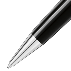 Imagem em close-up de uma caneta de resina Montblanc, exibindo seu elegante barril preto com um acabamento brilhante. A caneta apresenta uma ponta e um clipe em tom de prata, indicativos da atenção da marca aos detalhes e ao design de luxo. O contraste entre a resina preta e os elementos metálicos destaca a elegância deste instrumento de escrita