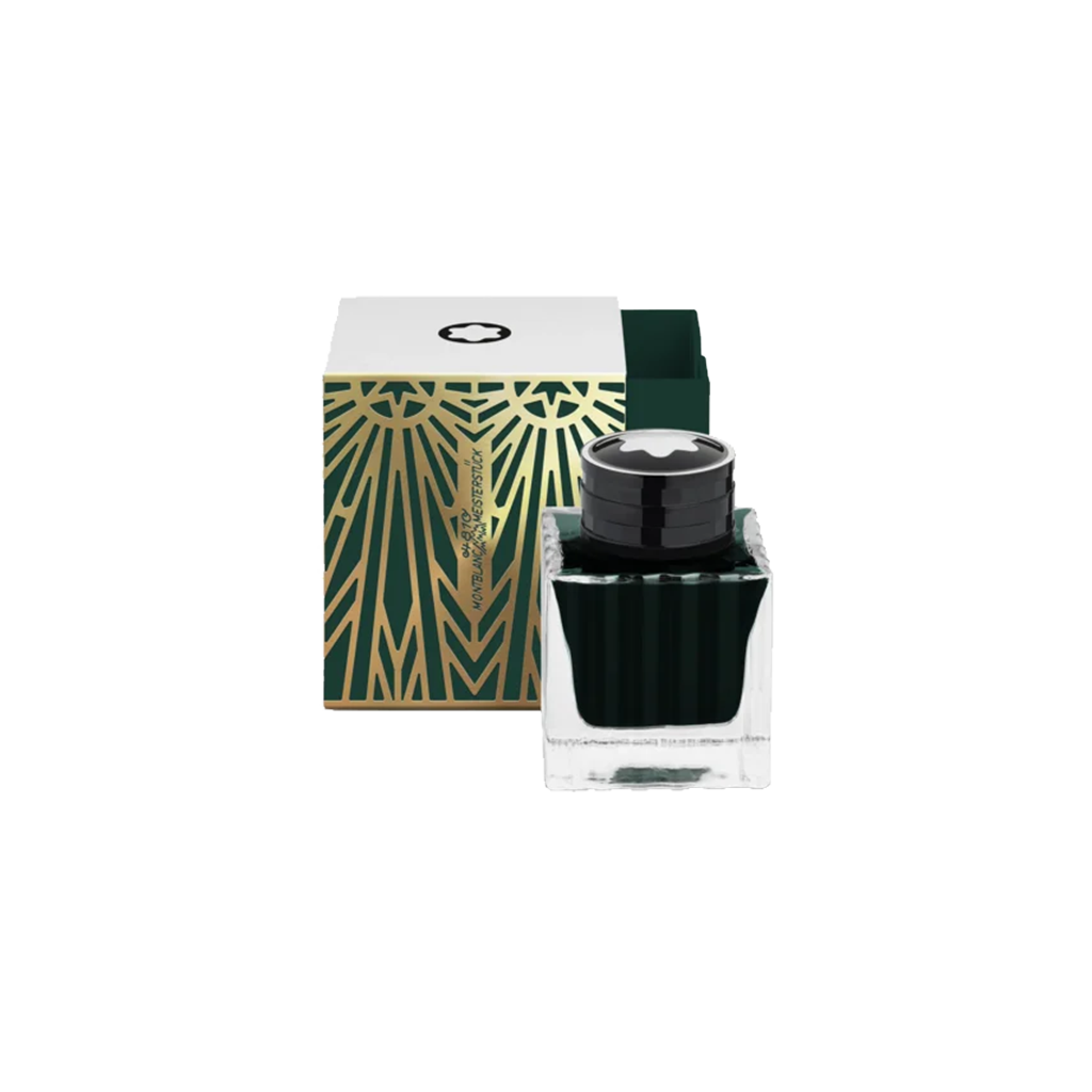 Um frasco de tinta Montblanc com uma tampa preta e a metade inferior transparente preenchida com tinta verde escura está colocado em frente à sua embalagem. A caixa é branca com um padrão geométrico verde e dourado e o logotipo da Montblanc no topo. O design sugere elegância e luxo, típicos da marca Montblanc