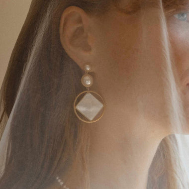 Senhora a usar os Brincos Majorica Nacar dourados redondos de 6 e 10mm