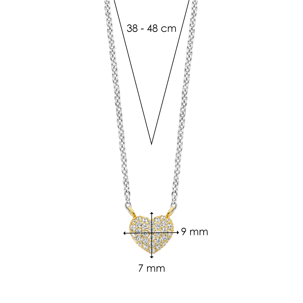 Colar de prata banhada a ouro com um pingente em forma de coração, adornado com zircónias. O pingente mede 9 mm de largura e 7 mm de altura. A corrente tem um comprimento ajustável entre 38 e 48 cm.