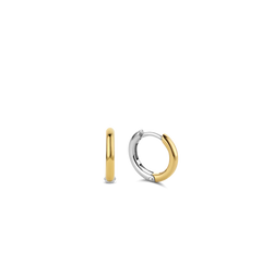 Imagem de um par de argolas feitas à mão, com base em prata e banhadas a ouro. O design é simples e elegante, com um acabamento liso e um mecanismo de fecho sem emendas, refletindo a habilidade artesanal envolvida na sua criação.