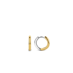 Imagem de um par de argolas feitas à mão, com um design onde metade é em prata e a outra metade é banhada a ouro, criando um efeito bicolor. As argolas estão posicionadas verticalmente contra um fundo branco, com uma argola de frente mostrando a junção entre as seções de prata e ouro, e a outra de lado, exibindo a espessura e a curvatura do design.