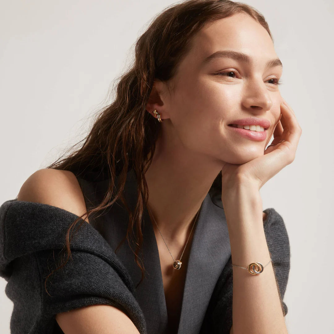 Senhora com os Brincos Ti Sento - Milano Prata 925 prateados em cruz com uma diagonal do X revestida em zircónias e a outra dourada