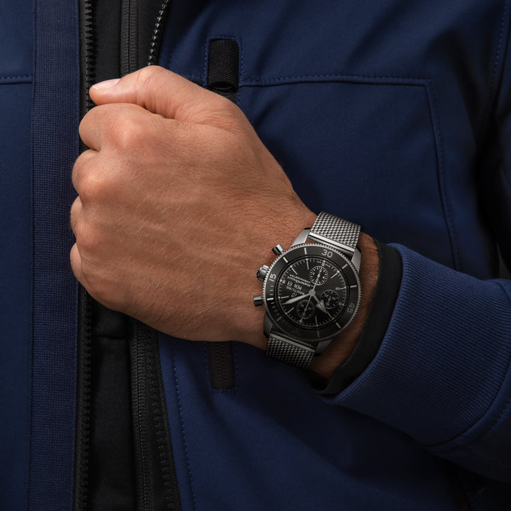 Pulso homem com relógio Superocean Heritage Chronograph totalmente prateado com mostrador preto