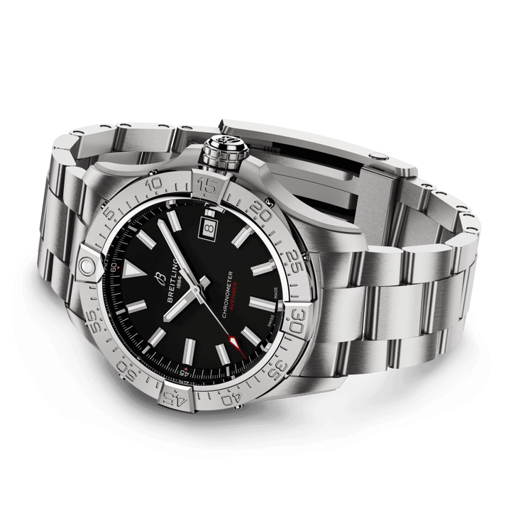 Uma imagem em close-up de um relógio de pulso Breitling com uma pulseira de aço inoxidável. O relógio tem um mostrador preto com marcadores de hora luminosos e ponteiros Mercedes, uma janela de data às 3 horas com uma lente de aumento, e uma moldura graduada fixa de 24 horas. O ponteiro dos segundos tem a ponta vermelha, adicionando contraste ao design. O relógio está contra um fundo branco que destaca seu design elegante e luxuoso.
