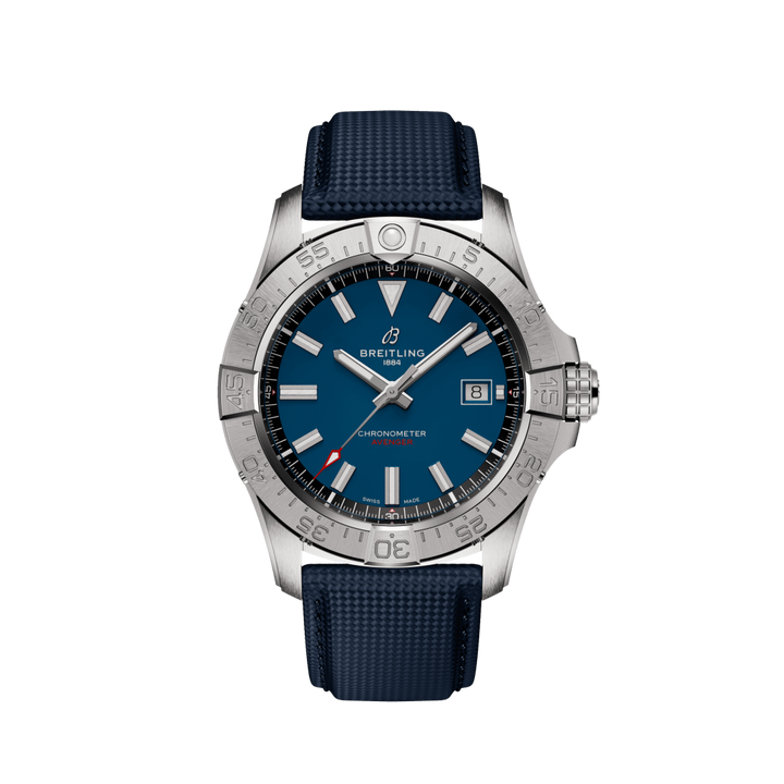 Um cronómetro Breitling com um mostrador azul, marcadores de hora brancos e prateados, e uma janela de data na posição das 3 horas. O relógio tem uma moldura prateada com números e marcações, e está equipado com uma pulseira texturizada azul. O design geral transmite luxo e precisão.