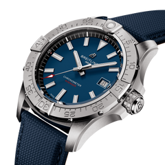 Uma imagem em close-up de um cronômetro Breitling. O relógio tem um mostrador azul com ponteiros e marcadores de hora em tom de prata, e uma janela de data na posição das 3 horas. Possui uma caixa de aço inoxidável com numerais gravados na moldura e está preso a uma pulseira de borracha texturizada azul. O ponteiro dos segundos é vermelho, adicionando um contraste ao esquema de cores azul e prata.