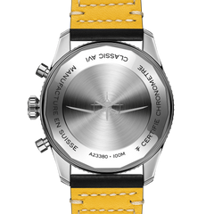 Imagem em close de um relógio de pulso Breitling com mostrador azul, detalhes em branco e prata, e submostradores. A caixa é de aço inoxidável com aro dentado, e a pulseira é de couro bovino preto com costura branca. Os ponteiros são luminosos e há uma função de data ao lado da posição das 3 horas. O logotipo da Breitling está visível abaixo da posição das 12 horas.