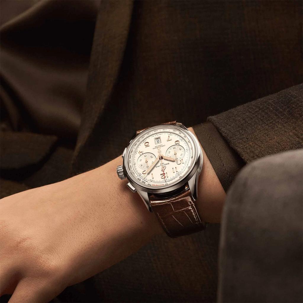 Pulso homem com Relógio Breitling Premier B01 Chronograph 42mm de caixa prateada, pulseira de pele castanha com mostrador creme