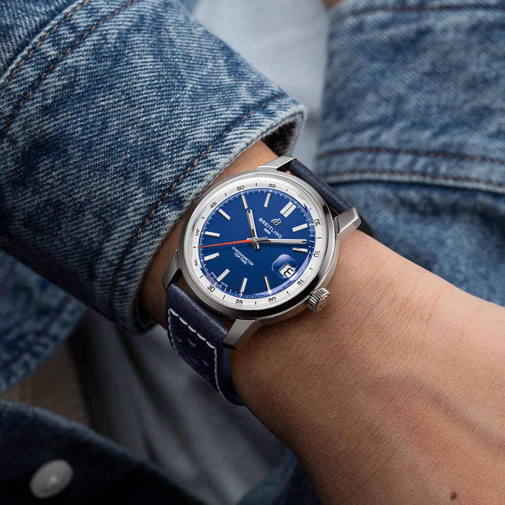 Pulso homem com Relógio Breitling Top Time B31 38mm de caixa prateada, pulseira de pele azul escura com mostrador azul com rebordo branco