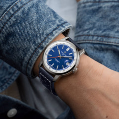 Pulso homem com Relógio Breitling Top Time B31 38mm de caixa prateada, pulseira de pele azul escura com mostrador azul com rebordo branco