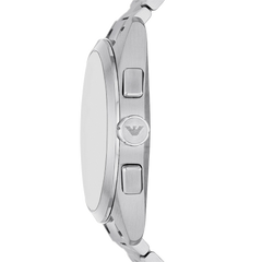 Imagem em close de um relógio Emporio Armani de aço inoxidável, mostrando o perfil lateral. O relógio tem acabamento polido com dois botões de pressão e o logotipo da Emporio Armani gravado na coroa localizada entre eles.