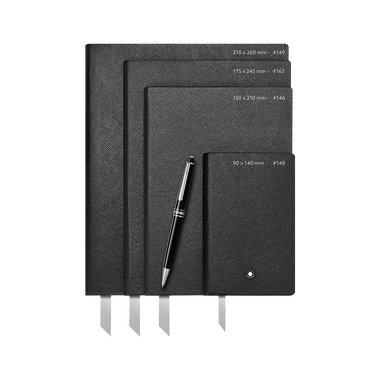 Três cadernos de capa dura pretos de tamanhos variados empilhados uns sobre os outros com uma caneta preta deitada diagonalmente sobre eles. O caderno maior tem as dimensões 210 x 260 mm escritas nele, o médio tem 175 x 245 mm, e o menor tem 90 x 140 mm. Todos os cadernos têm uma fita marcadora visível e estão colocados contra um fundo branco.