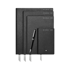 Três cadernos de capa dura pretos de tamanhos variados empilhados uns sobre os outros com uma caneta preta deitada diagonalmente sobre eles. O caderno maior tem as dimensões 210 x 260 mm escritas nele, o médio tem 175 x 245 mm, e o menor tem 90 x 140 mm. Todos os cadernos têm uma fita marcadora visível e estão colocados contra um fundo branco.