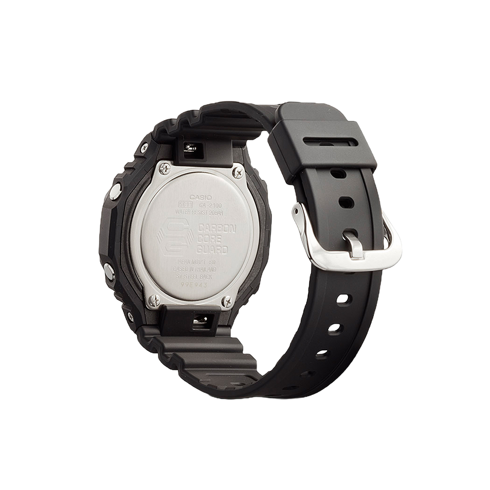 Um relógio Casio de resina com uma pulseira preta exibido contra um fundo simples. O relógio tem uma moldura redonda texturizada e uma fivela prateada. A parte traseira do relógio, visível nesta vista, mostra várias inscrições, incluindo o nome da marca, o número do modelo (3229) e informações sobre resistência à água (20 BAR