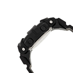 Um close-up de um relógio de resina preta visto de lado, destacando a pulseira e a caixa do relógio. A pulseira é composta por segmentos ligados com parafusos metálicos nas juntas, conferindo um visual robusto e durável. A caixa é espessa, sugerindo um design resistente. Não há características visíveis indicando a marca ou funcionalidades adicionais nesta seção do relógio.