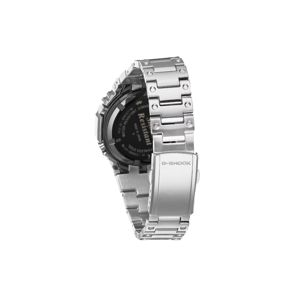 Um relógio de pulso de aço inoxidável com uma pulseira de elos. O relógio possui um display digital preto com vários indicadores e um logotipo de marca proeminente na parte superior. A caixa e a pulseira apresentam um acabamento polido, refletindo a luz nas superfícies.