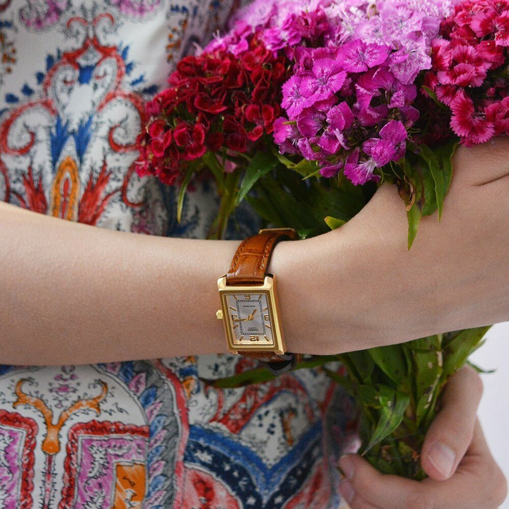 Pulso senhora com relógio Casio Timeless com pulseira couro castanha e mostrador branco e caixa dourada