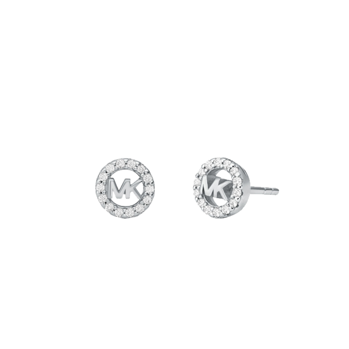 Um par de brincos de tacha da Michael Kors, feitos de prata banhada a ródio. Cada brinco apresenta um design circular com um halo de pedras de zircônia cercando o logotipo central ‘MK’