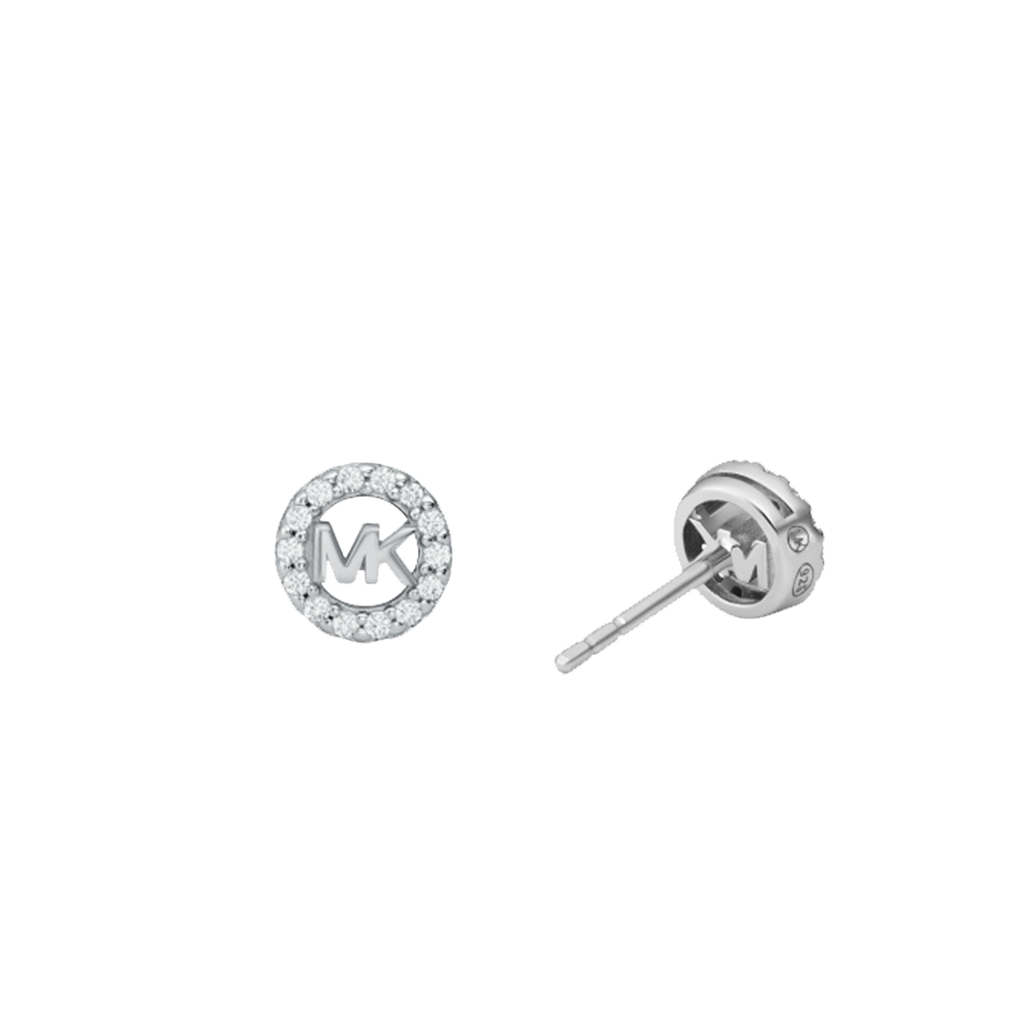 Um par de brincos de tacha de prata banhada a ródio com zircônia da Michael Kors. Cada brinco apresenta um proeminente logotipo ‘MK’ no centro, cercado por um halo de pequenas pedras de zircônia cintilantes. O design é elegante e simétrico, com um brinco voltado para a frente e o outro virado para mostrar o lado e a parte de trás, revelando um fecho de tarraxa.