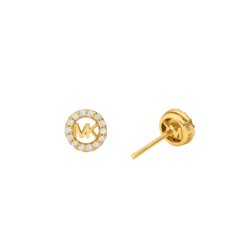 Um par de brincos de tacha da Michael Kors, apresentando um design de prata banhada a ouro com um logotipo central ‘MK’ cercado por pequenas pedras de zircônia, contra um fundo branco. Os brincos têm um fecho de tarraxa visível em uma das tachas. A imagem mostra um par de brincos da Michael Kors que são interessantes devido à sua marca de designer e à combinação de banho de ouro com zircônia, que imita a aparência de diamantes, oferecendo uma opção de acessório elegante e luxuoso.