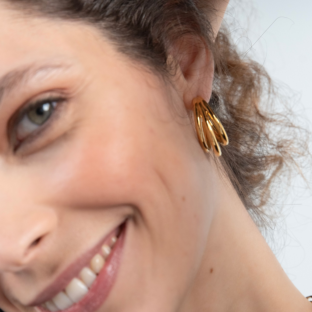 imagem de mulher sorridente a usar os brincos ONE Luminous triple