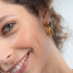 imagem de mulher sorridente a usar os brincos ONE Luminous triple