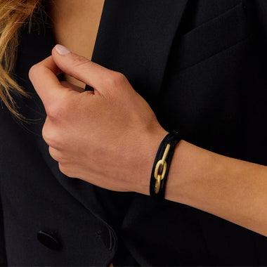 Senhora com Conjunto Colar & Pulseira NANIS Libera Soul - Pulseira com 4 voltas de fio preto com terminais dourados e 3 formas ovais em formato corrente dourada no centro