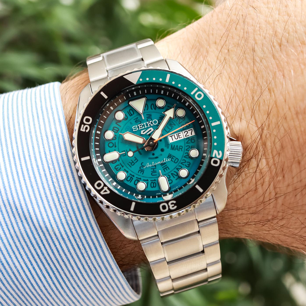 imagem do relógio 5 Sports Black-Blue pulseira de aço inoxidável prateado com mostrador azul transparente no pulso de um senhor