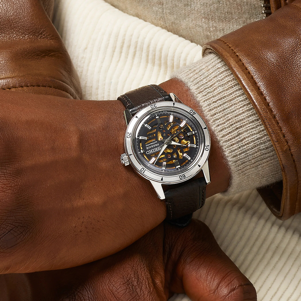 Pulso homem com Relógio Seiko Presage Style 60's 39.5mm de pulseira pele preta e castanha, com caixa prateada e  mostrador preto com detalhes amarelos