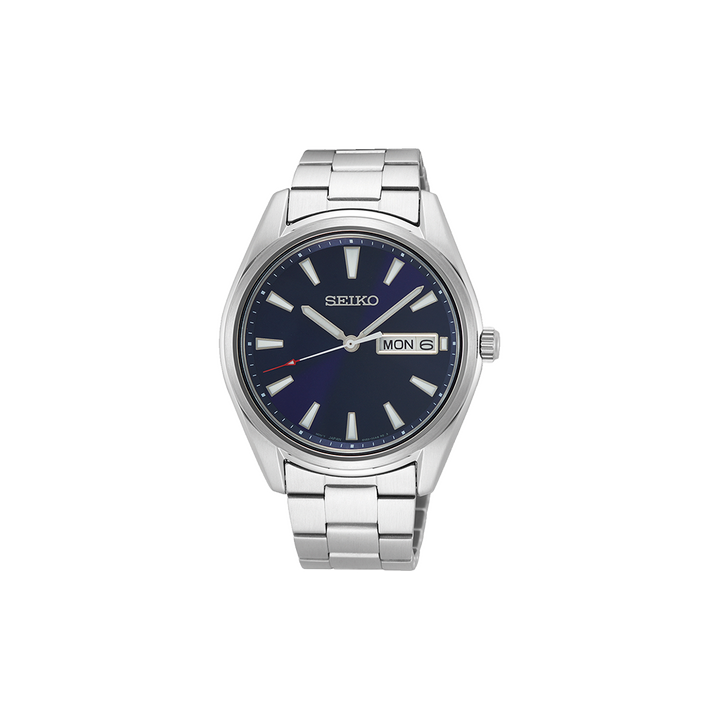 Relógio de pulso Seiko de aço inoxidável com mostrador azul escuro e marcadores prateados. O mostrador exibe o dia da semana na parte superior e a data na parte inferior, ambos próximos à marca das 3 horas. A caixa e a pulseira são de aço polido e escovado, conferindo um visual sofisticado adequado para várias ocasiões.