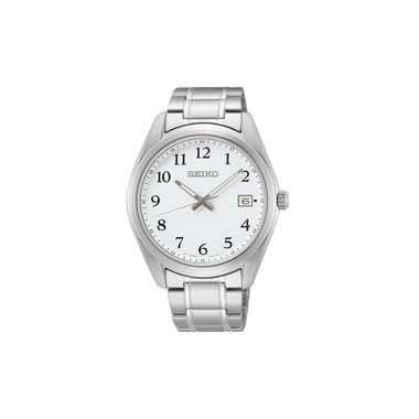 Um relógio de pulso Seiko de aço inoxidável com mostrador branco e algarismos arábicos pretos para cada hora. O relógio possui três ponteiros - dois pretos e um dourado - indicando as horas, minutos e segundos. Há um visor de data na posição das 3 horas. A caixa e a pulseira do relógio são de aço inoxidável polido, refletindo a luz em sua superfície.