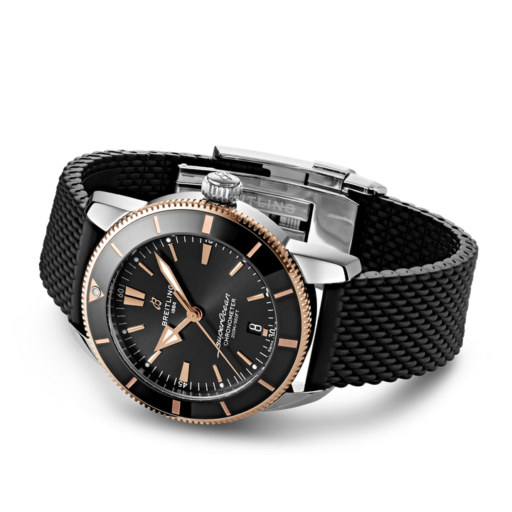 Relógio Breitling Superocean Heritage B20 Automatic 44mm de caixa prateada, pulseira silicone e mostrador pretos com detalhes rosa dourado deitado de lado