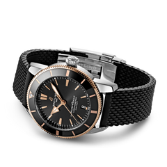 Relógio Breitling Superocean Heritage B20 Automatic 44mm de caixa prateada, pulseira silicone e mostrador pretos com detalhes rosa dourado deitado de lado