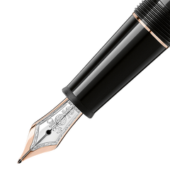 Imagem em close-up de uma caneta de tinteiro com um aparo feito à mão em ouro 14k apresentando incrustações revestidas a ródio. A caneta tem um elegante barril preto com uma seção de aderência texturizada, e o aparo exibe gravações intrincadas que realçam sua elegância. Esta imagem é interessante porque mostra o artesanato e os materiais luxuosos usados na criação de instrumentos de escrita de alta qualidade