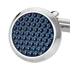 Imagem em close-up de um botão de punho redondo e prateado com laca de pedra azul. O botão de punho apresenta um padrão hexagonal detalhado na laca, dando-lhe uma aparência texturizada. O nome da marca ‘MONTBLANC’ está gravado na borda de metal que circunda a pedra azul. O fundo é branco, destacando o design e a cor do botão de punho