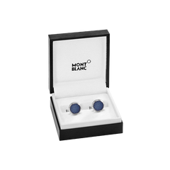 Um par de botões de punho da Montblanc com incrustações de cristal azul, apresentados numa caixa preta aberta com o logotipo da Montblanc no interior da tampa. Os botões de punho são redondos e parecem ser finamente trabalhados, refletindo a luz de suas superfícies multifacetadas, sugerindo um acessório luxuoso para trajes formais.