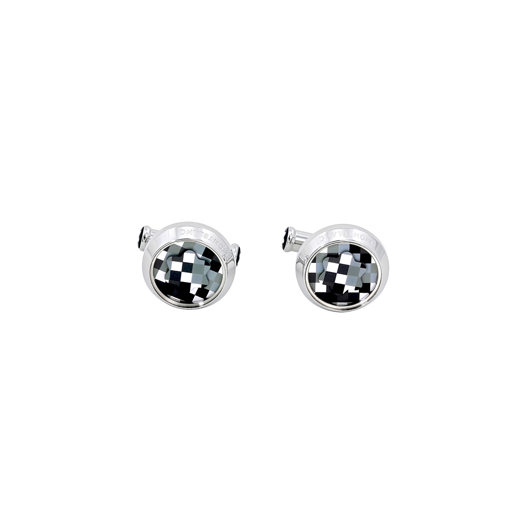 Um par de botões de punho com uma moldura redonda e prateada e um design quadriculado preto e branco no centro. O padrão cria uma ilusão óptica de profundidade tridimensional, assemelhando-se a um tabuleiro de xadrez que se curva para dentro. Os botões de punho estão definidos contra um fundo branco simples, destacando seu design intrincado e acabamento polido.