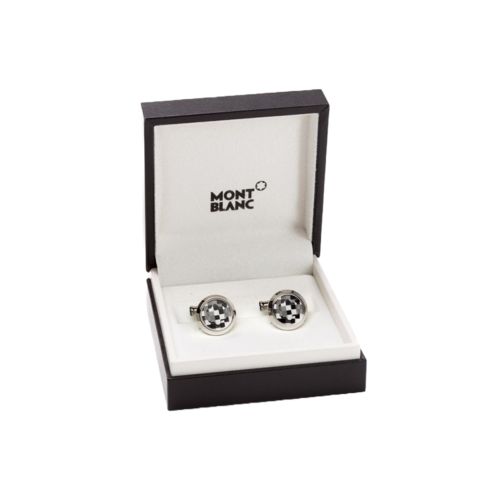 Uma caixa aberta da marca Montblanc contendo um par de botões de punho elegantes. Os botões de punho têm um design circular distinto com um padrão preto e branco contrastante que os destaca. Eles estão colocados nos slots dedicados dentro da caixa, que é marcada com ‘MONTBLANC’ na parte superior do interior. A apresentação em tal embalagem sugere que estes são acessórios de alta qualidade, possivelmente destinados a trajes formais ou como um presente de luxo.