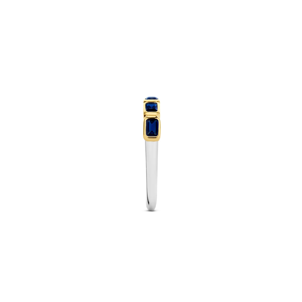 Imagem lateral de um anel de prata banhado a ouro amarelo, apresentando várias pedras retangulares de lapis lazuli dispostas em um engaste de canal, criando uma banda contínua de azul profundo ao longo da parte superior do anel. O contraste entre o banho de ouro amarelo e o rico azul das pedras de lapis lazuli torna esta peça visualmente impressionante.
