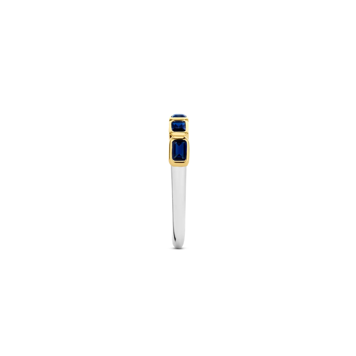 Imagem lateral de um anel de prata banhado a ouro amarelo, apresentando várias pedras retangulares de lapis lazuli dispostas em um engaste de canal, criando uma banda contínua de azul profundo ao longo da parte superior do anel. O contraste entre o banho de ouro amarelo e o rico azul das pedras de lapis lazuli torna esta peça visualmente impressionante.