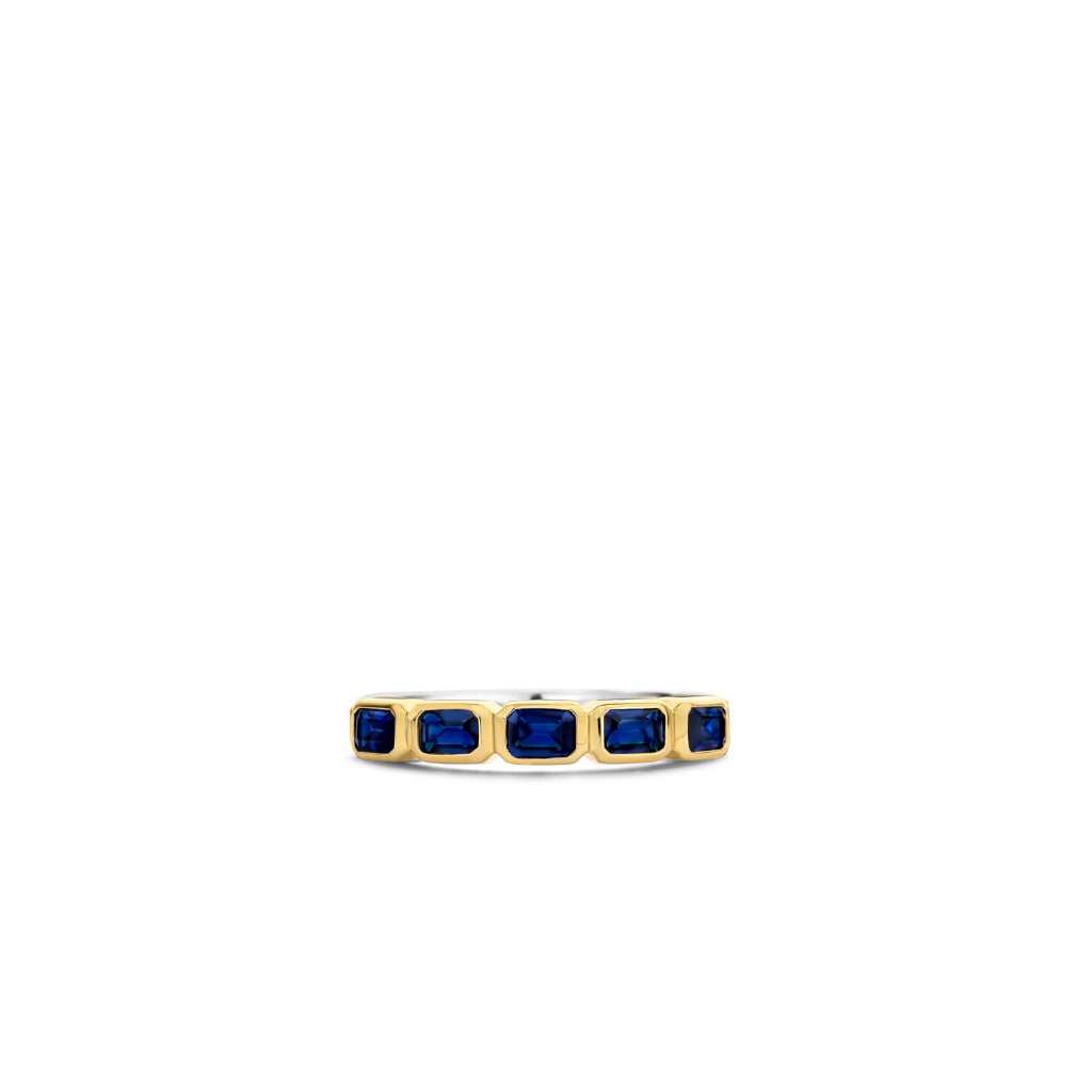 Imagem com vista superior de um anel de prata banhado a ouro amarelo, apresentando várias pedras retangulares de lapis lazuli dispostas em um engaste de canal, criando uma banda contínua de azul profundo ao longo da parte superior do anel. O contraste entre o banho de ouro amarelo e o rico azul das pedras de lapis lazuli torna esta peça visualmente impressionante.