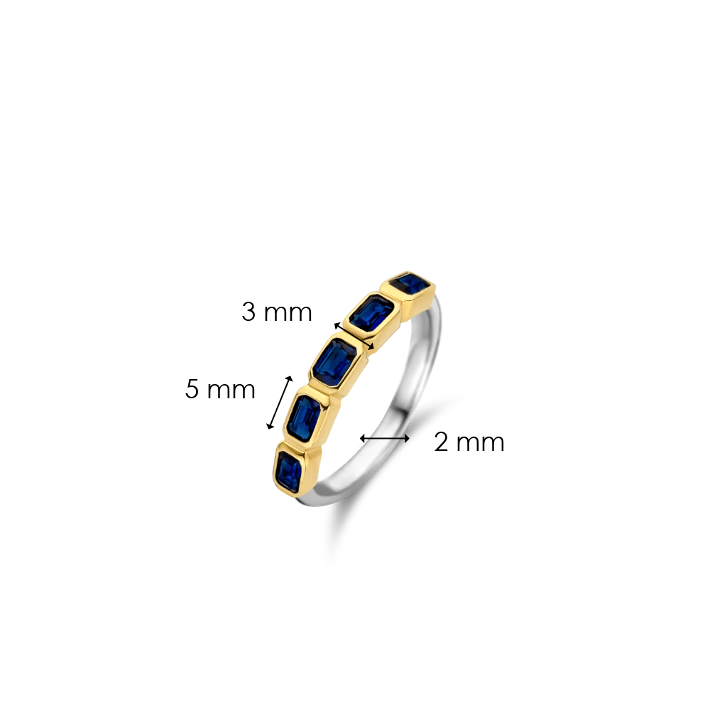Imagem de um anel esguio feito de prata com banho de ouro. O anel apresenta várias pedras retangulares de lapis lazuli dispostas em um engaste de canal ao longo da parte superior. As pedras são de um azul profundo com nuances de dourado. A largura da banda é indicada como 2 mm, a largura da área de engaste das pedras é de 3 mm, e a altura da base até o topo das pedras é de 5 mm.