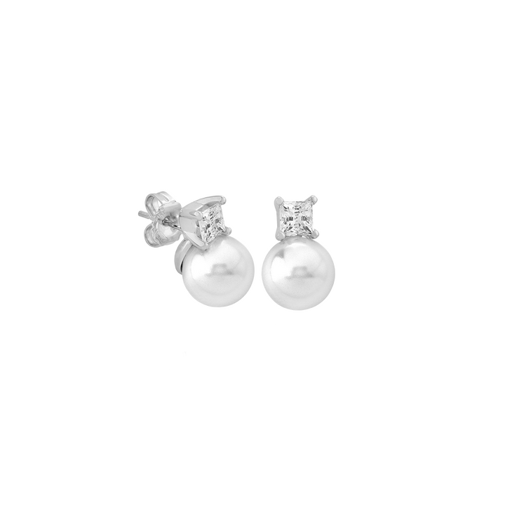 Um par de brincos de prata banhados a ródio, apresentando gotas de pérola Murano. Cada brinco tem uma pérola branca redonda e lustrosa pendurada abaixo de uma pedra cintilante de zircônia cúbica, fixada em uma configuração clássica de quatro garras. A combinação do revestimento reflexivo de ródio e as pérolas iridescentes cria uma peça elegante e atemporal de joalheria.
