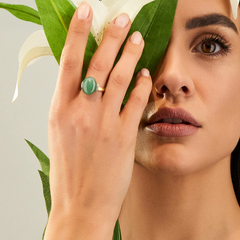 imagem de senhora com mão esquerda levantada a tapar parte da face com o anel Amuleti Amazonia no dedo do meio