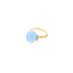 imagem lateral do anel Amuleti azure com pedra água-marinha leitosa rodeado de diamantes nas laterais e com aro em ouro de 18k