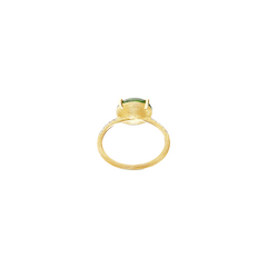 Imagem de um anel de ouro com uma banda texturizada e uma única pedra preciosa verde grande, montada em uma configuração de quatro garras